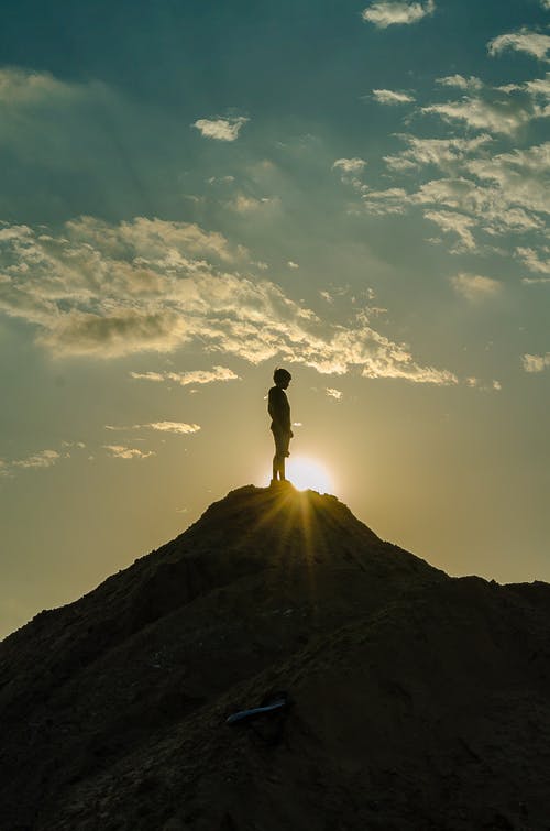 一个男人站在一座山的轮廓 · 免费素材图片