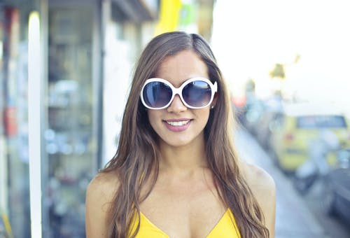 女人穿着黄色意大利面条表带顶部和圆形太阳镜 · 免费素材图片