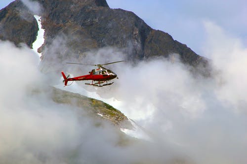 在有雾的山顶的红色直升机 · 免费素材图片
