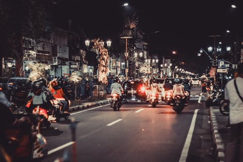 人们在夜间骑摩托车在路上 · 免费素材图片