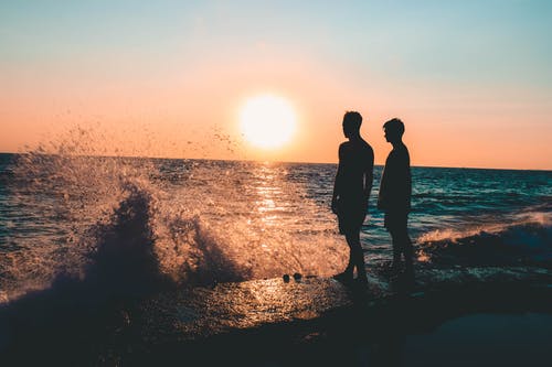 两名男子站在海边 · 免费素材图片