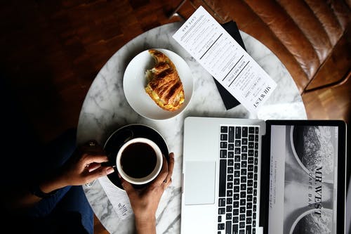Macbook Pro和桌上的一杯咖啡 · 免费素材图片