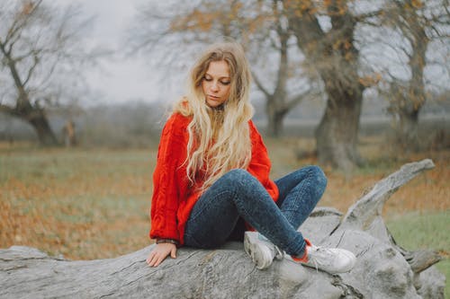 坐在毛衣上的红色毛衣的女人 · 免费素材图片