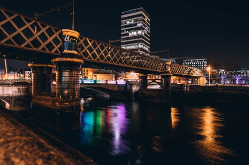 棕色混凝土桥梁和高层建筑在夜间的建筑照片 · 免费素材图片