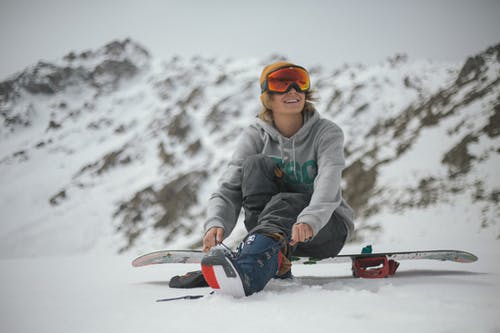 坐在滑雪板上的灰色连帽衫的人 · 免费素材图片