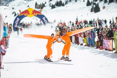 穿着橙色西装的男人摄影滑雪板 · 免费素材图片
