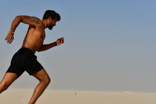 坚强的赤膊运动员在晴朗的一天慢跑 · 免费素材图片