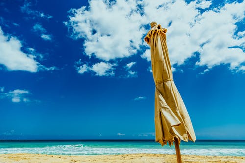 海边的棕色伞 · 免费素材图片