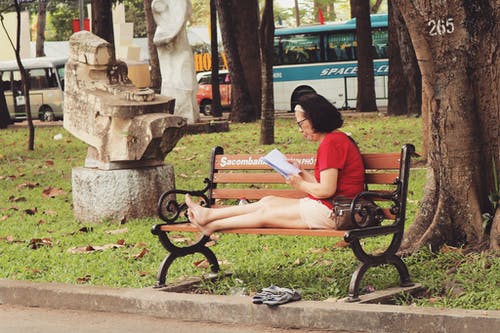 穿红衬衫，坐在长椅上的女人 · 免费素材图片