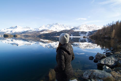 女人穿着黑色连帽外套看山 · 免费素材图片