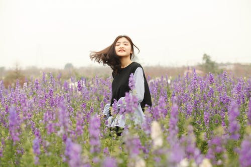 黑色和白色长袖上衣在花园里的女人 · 免费素材图片