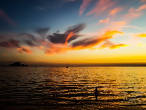 黄金时段在平静的天空下的水体 · 免费素材图片