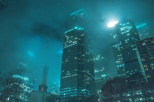 夜间建筑物旁边的高层建筑 · 免费素材图片