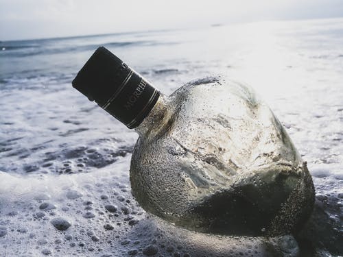 水体上的透明玻璃瓶 · 免费素材图片