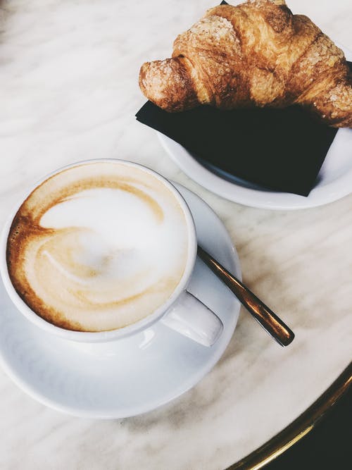卡布奇诺咖啡和牛角包 · 免费素材图片