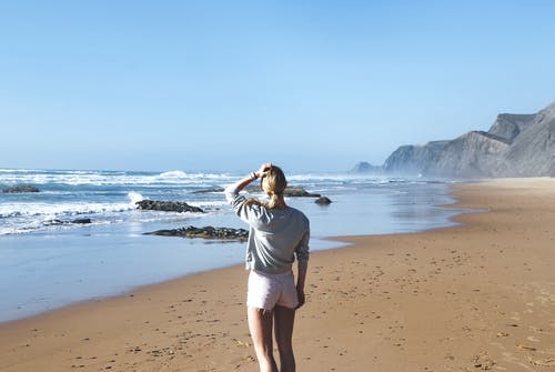 灰色长袖衬衫，站在海边的粉红色短短裤的女人 · 免费素材图片