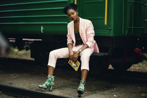 坐在绿色火车上的粉红色西装外套的女人 · 免费素材图片