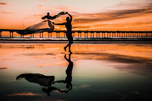 拿着围巾的人的剪影照片 · 免费素材图片