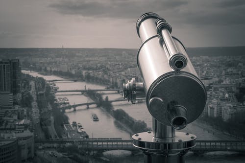 俯瞰城市河岸的观测望远镜的灰度摄影 · 免费素材图片