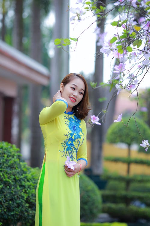 穿黄色和蓝色的花卉3/4袖连衣裙的女人的照片 · 免费素材图片
