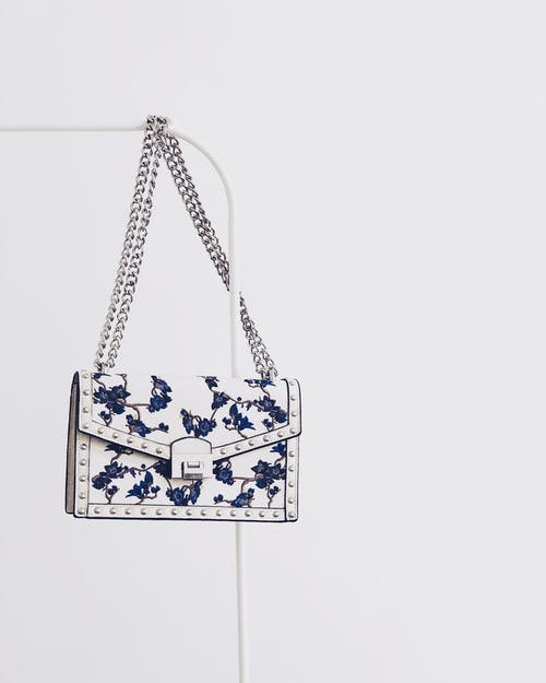 白色和蓝色的花朵皮瓣吊索袋挂在白钢架上 · 免费素材图片