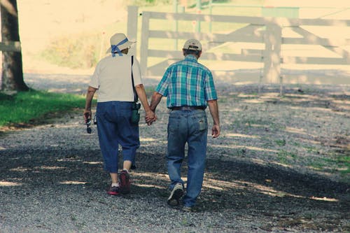 老夫妇手牵着手散步 · 免费素材图片