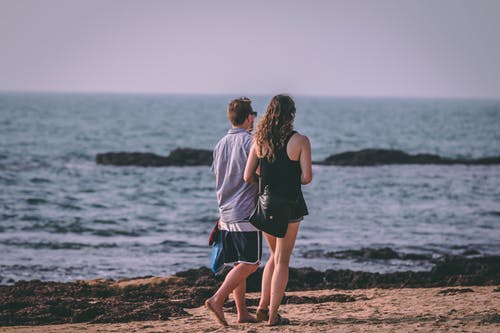 女人和男人在海边散步 · 免费素材图片