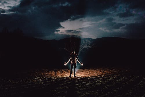 站在篝火旁，手放在一边的人 · 免费素材图片