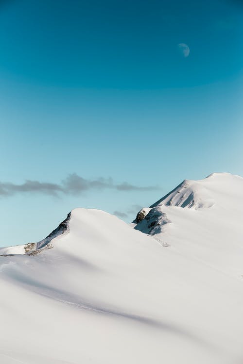 月亮下的白雪覆盖的山脉照片 · 免费素材图片