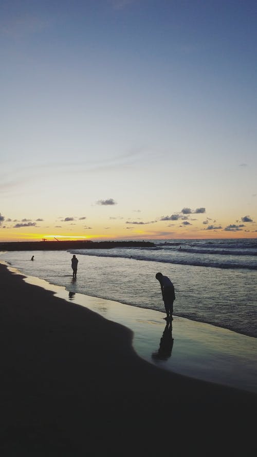 两人在日出时的海滩 · 免费素材图片