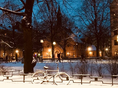 夜间在栅栏附近的积雪的自行车 · 免费素材图片