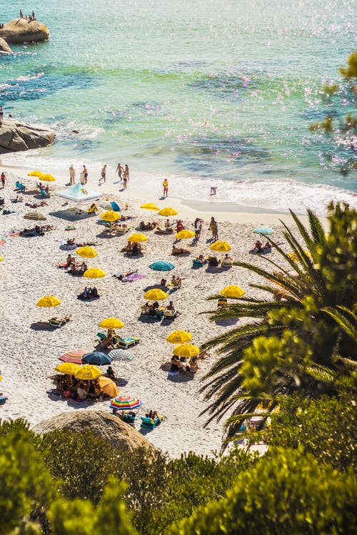 人们在海边晒日光浴和游泳 · 免费素材图片