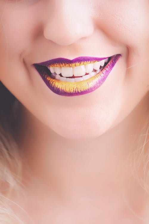 显示她的紫色和黄色唇膏的女人 · 免费素材图片