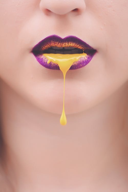 妇女的紫色和黄色嘴唇与黄色液体 · 免费素材图片