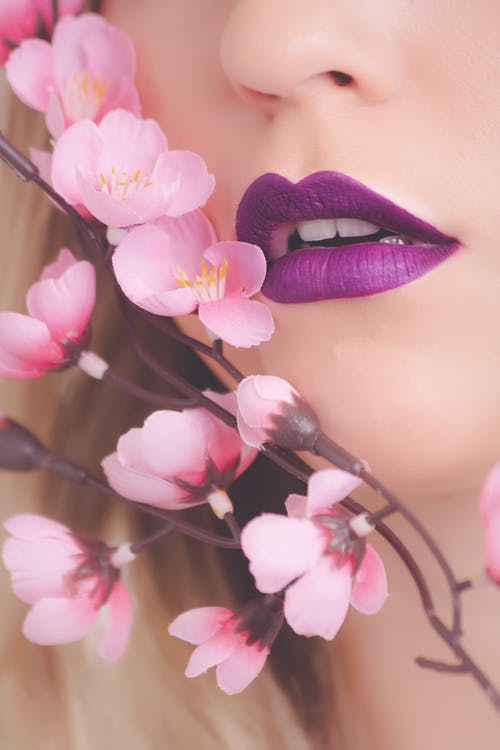 女人显示她的紫色唇膏 · 免费素材图片