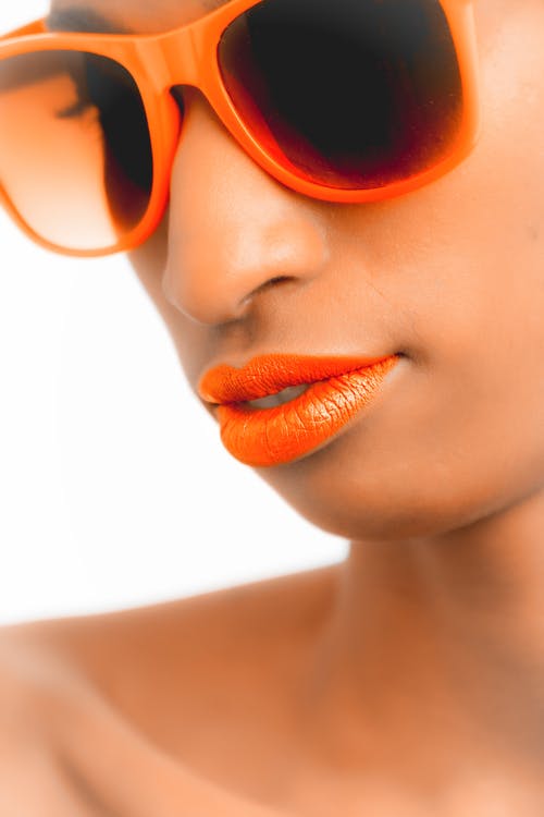女人戴着橙色镜框的徒步旅行者风格太阳镜的特写镜头和选择性焦点照片 · 免费素材图片