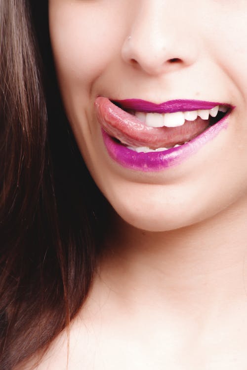 女人舔着紫色的嘴唇 · 免费素材图片