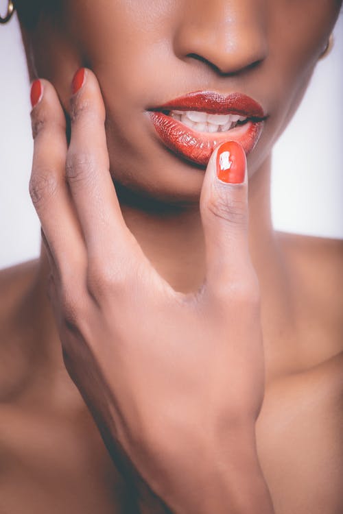 红色的唇膏和红色指甲的女人 · 免费素材图片