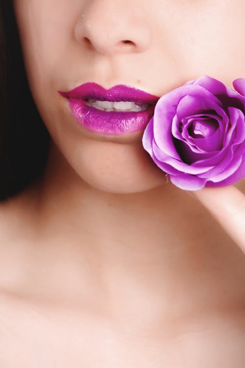拿着粉红色玫瑰的粉红色唇膏的女人 · 免费素材图片