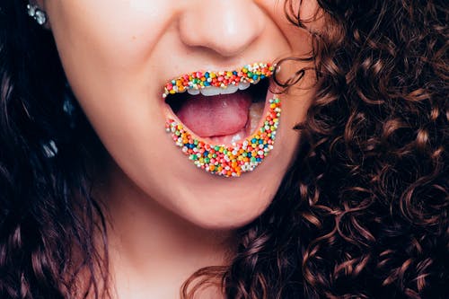 女人张开嘴与多彩多姿的糖果 · 免费素材图片