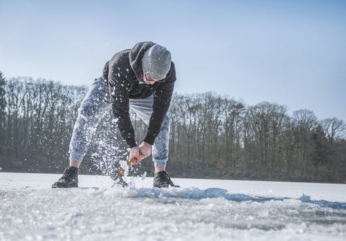 在雪原上拿着铁锹的人 · 免费素材图片