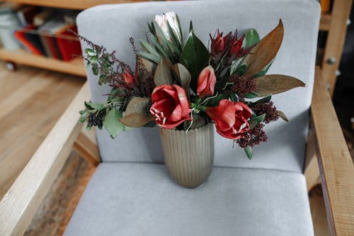 在扶手椅上的花瓶里的红色郁金香花 · 免费素材图片