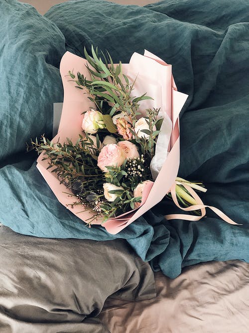 床单上的粉色和绿色花束 · 免费素材图片