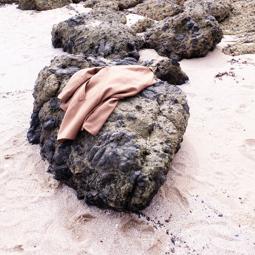 黑石头上的棕色外套 · 免费素材图片