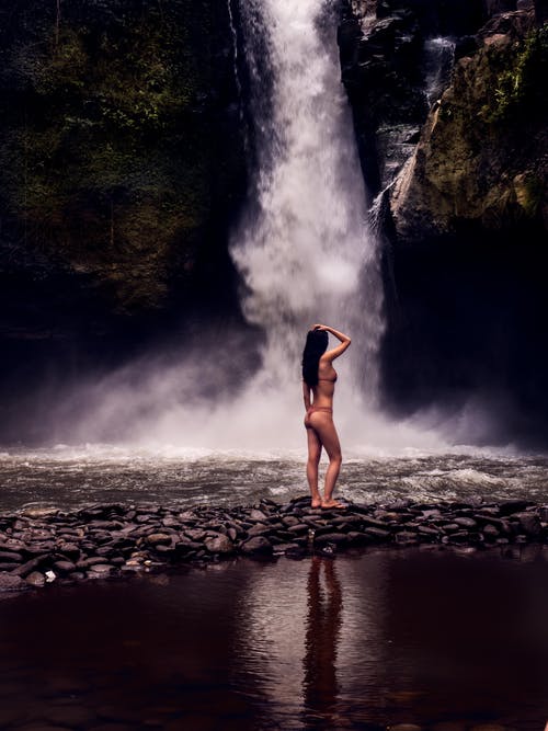 在瀑布前穿比基尼的女人的照片 · 免费素材图片