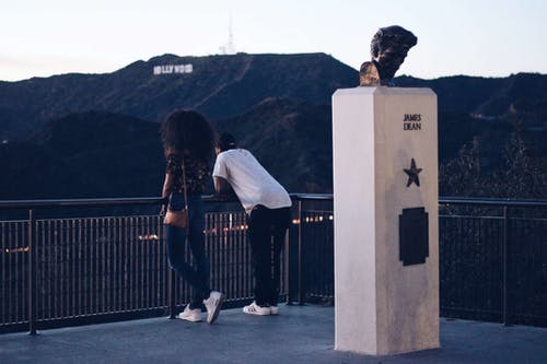 男人和女人站在黑金属栏杆附近 · 免费素材图片