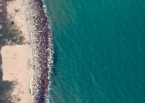 水体旁边的棕色和灰色岩石 · 免费素材图片