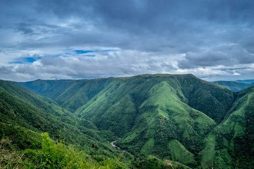 多云的天空下的绿山景观摄影 · 免费素材图片