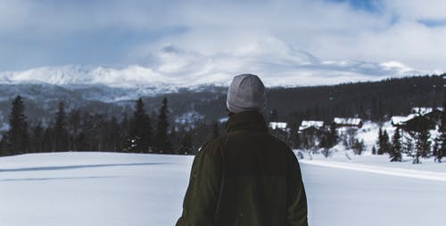 黑色外套和灰色针织帽站在白色的雪地上的男人 · 免费素材图片