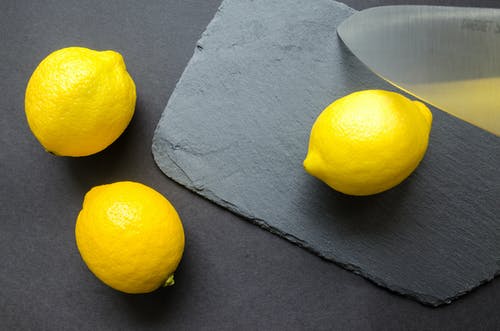 灰色表面上的三个柠檬 · 免费素材图片